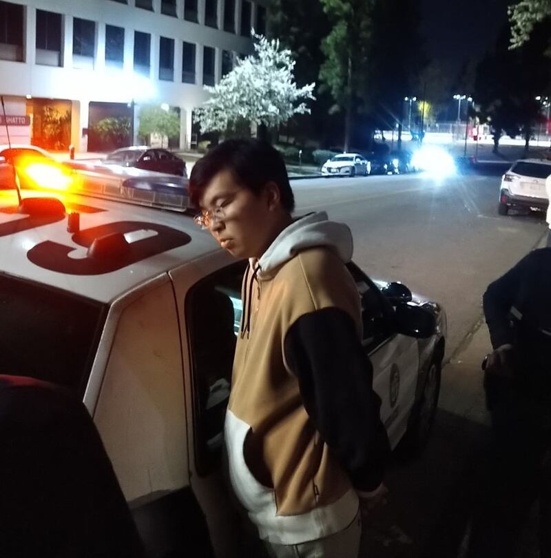 一个疑似小粉红的中国留学生模样的年轻人,踢倒摆放的花圈,并拉扯活动投影幕布。当时几个人一边抓住他一边呼叫警察,警察很快过来将他拷上,搜身时发现一把折叠刀。(界立建提供)